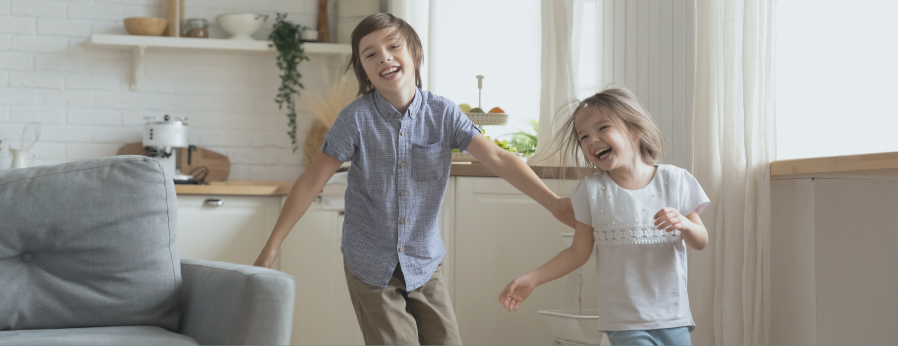 Brother and sister running through house laughing